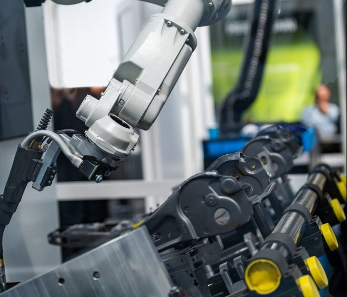 Robotic arm welding system in a manufacturing production plant